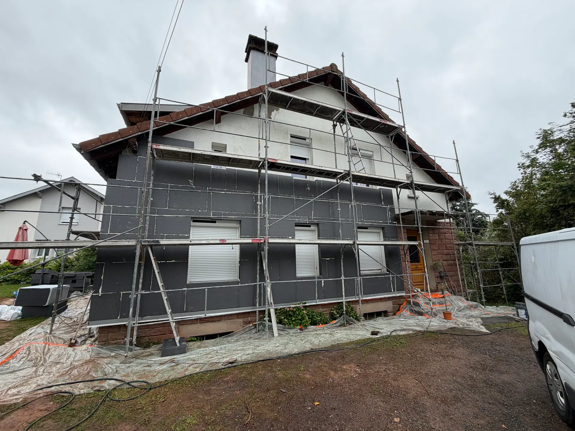 Isolation thermique par l'extérieur à Saint-Dié-des-Vosges — panneaux isolants gris posés sous le pignon, échafaudage en place