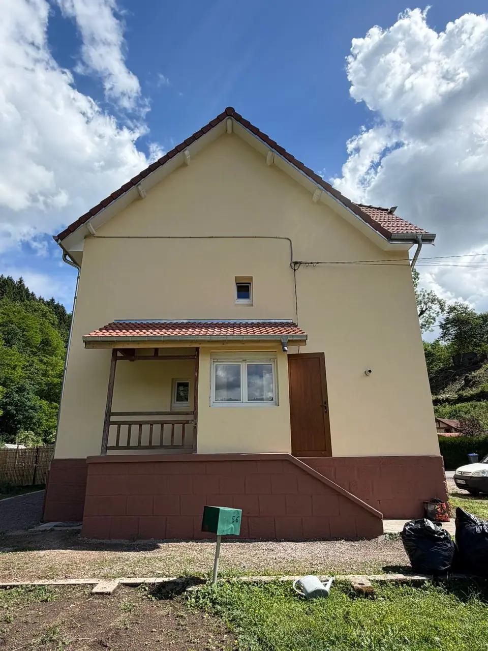 Ravalement de façade à Senones — pignon ravalé, soubassement structuré et auvent au-dessus du porche